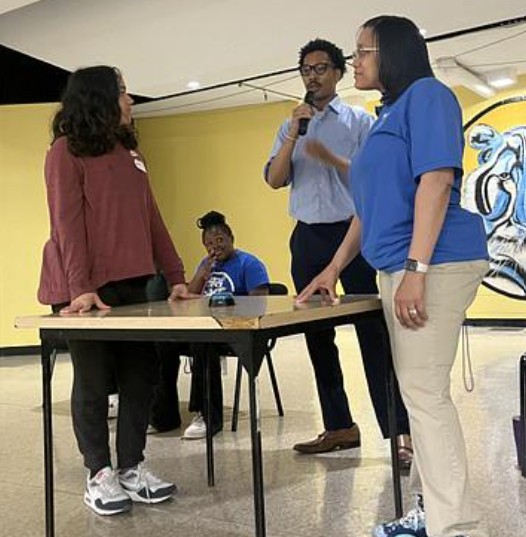  teacher and student standing at table on stage